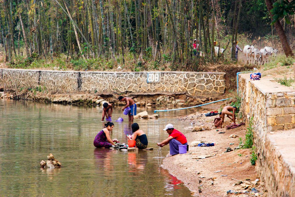 Frauen waschen Klammotten im Indein Dorf