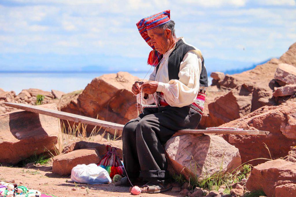 Quechua Mann strickt auf Taquile