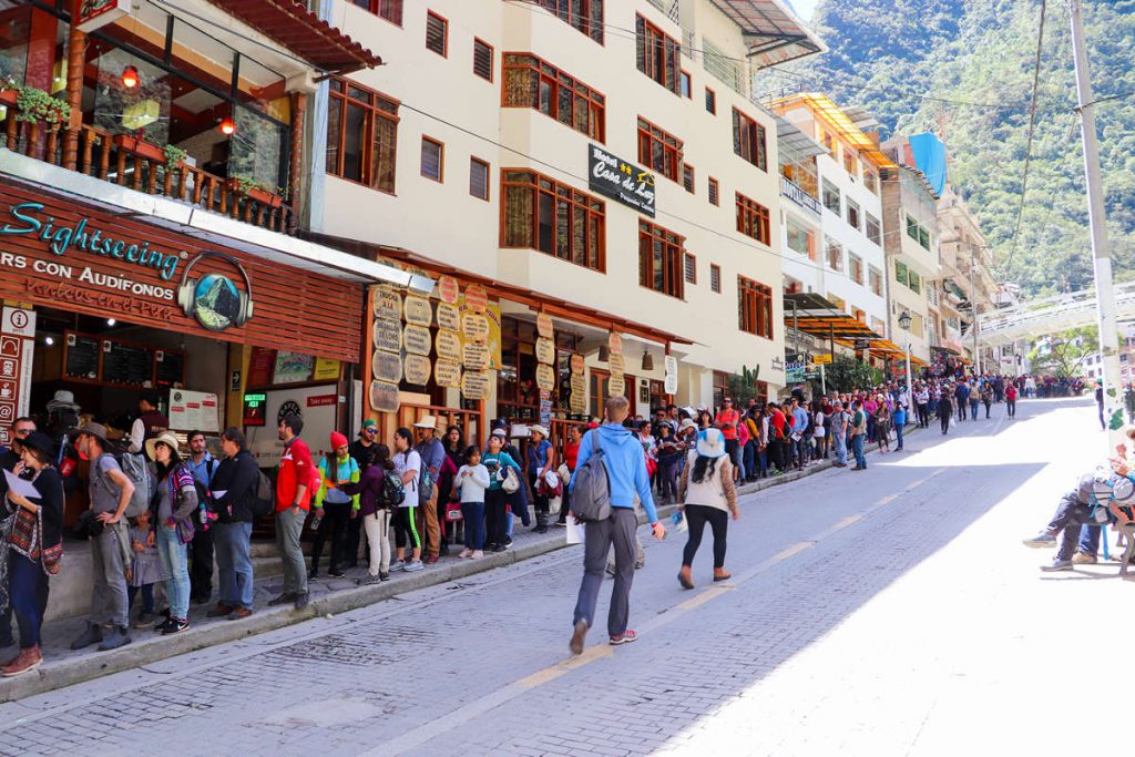 Touristen warten auf die Busse in Aguas Calientes